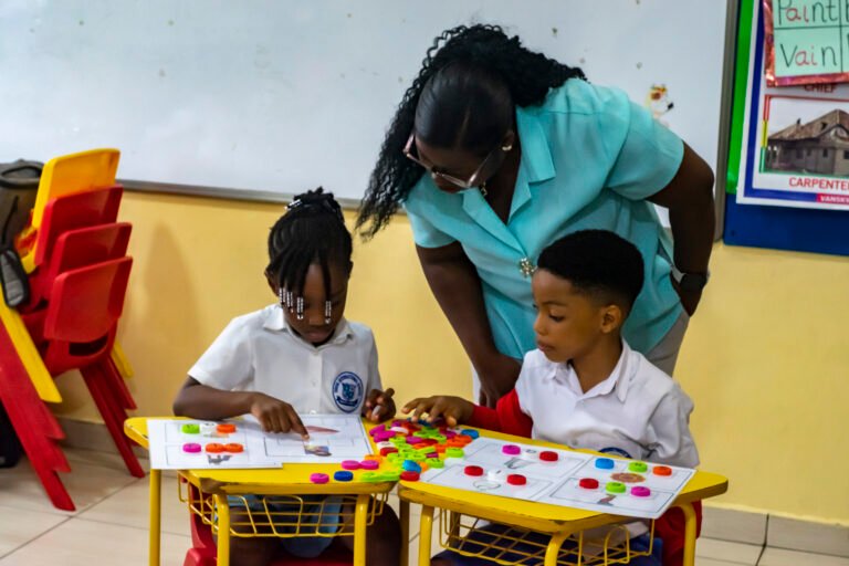 Early Years teacher helping children with a table activity