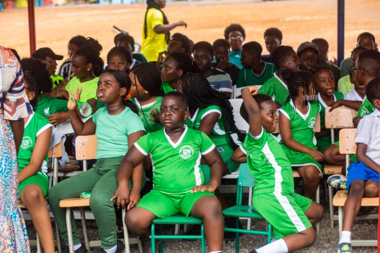 Learners watching sports day on the school field