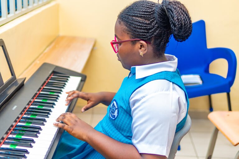 Learner playing the keyboard in a music lesson
